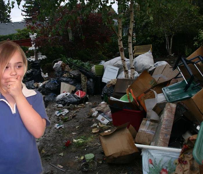 girl standing in yard filled with garbage and junk