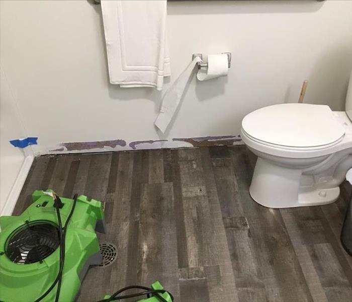 image of bathroom and toilet with SERVPRO drying fans on floor 